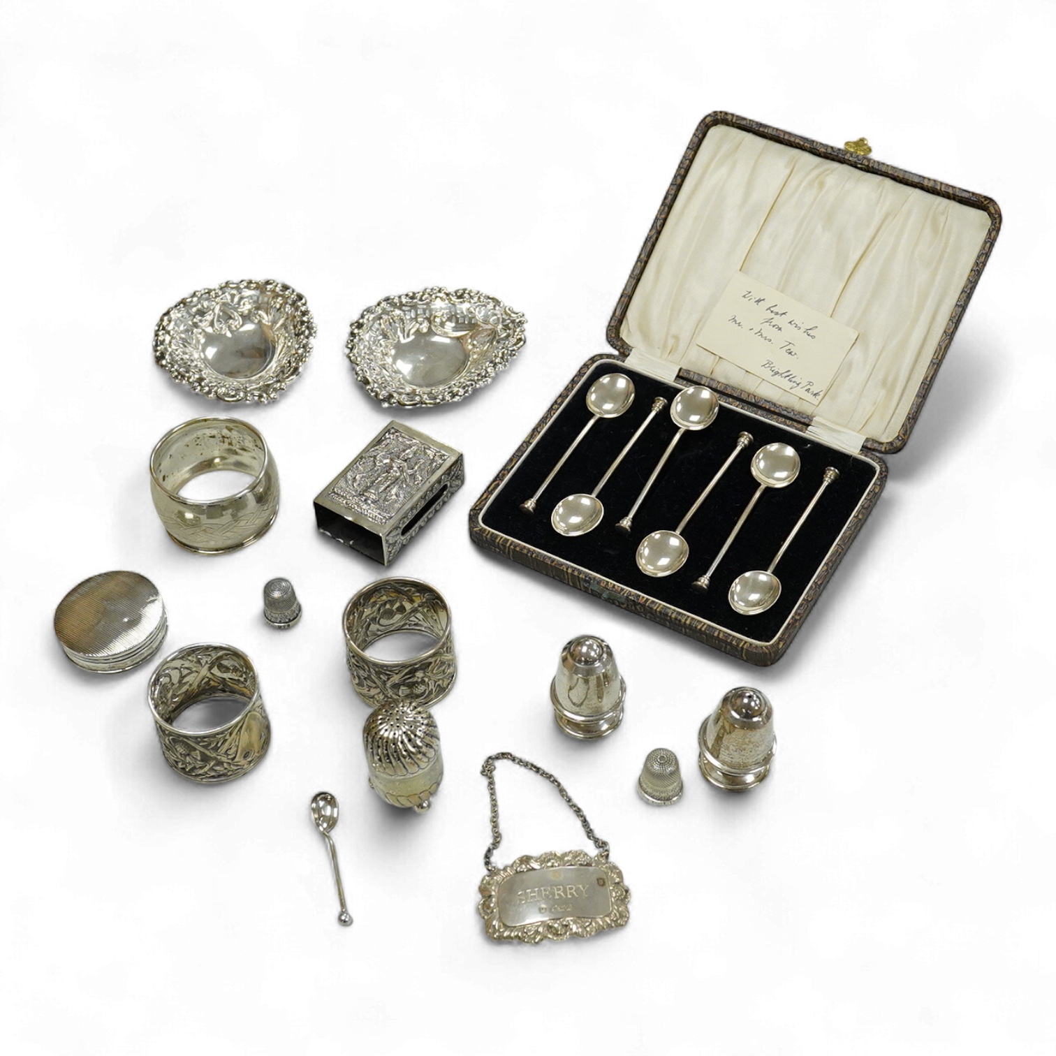 A collection silver and white metal to include a cased set of six George V seal top coffee spoons, Birmingham, 1927, a pair of Scottish napkin rings embossed with thistles, a pair of embossed heart shaped bonbon dishes,